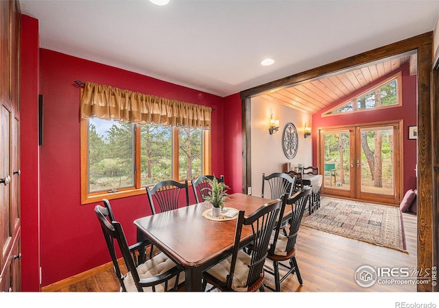 dining space featuring french doors, vaulted ceiling with beams, baseboards, and wood finished floors