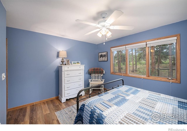 bedroom featuring ceiling fan, wood finished floors, and baseboards