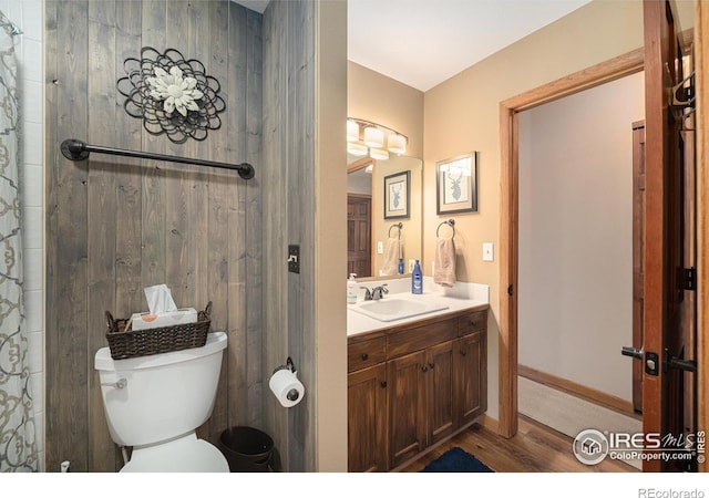 full bath featuring baseboards, vanity, toilet, and wood finished floors