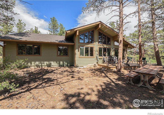 rear view of house featuring a wooden deck