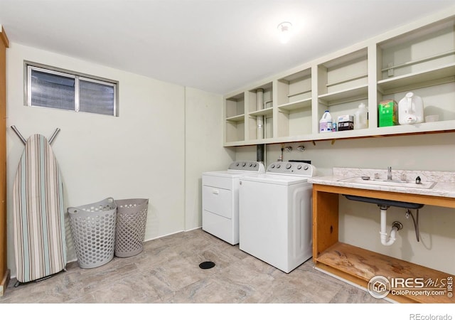 washroom featuring laundry area, separate washer and dryer, and a sink