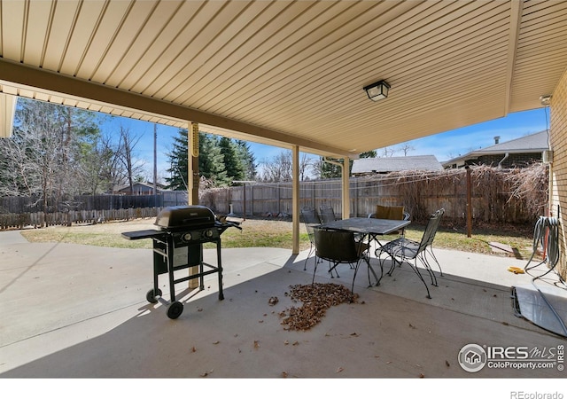 view of patio featuring outdoor dining space, area for grilling, and a fenced backyard