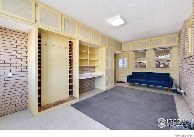 mudroom with brick wall