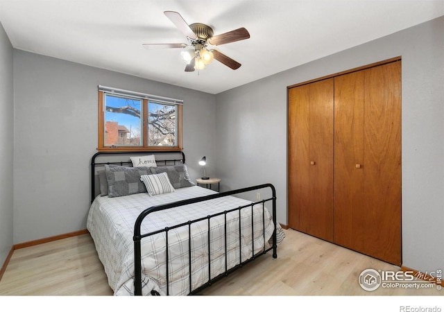 bedroom with a ceiling fan, light wood-style flooring, baseboards, and a closet