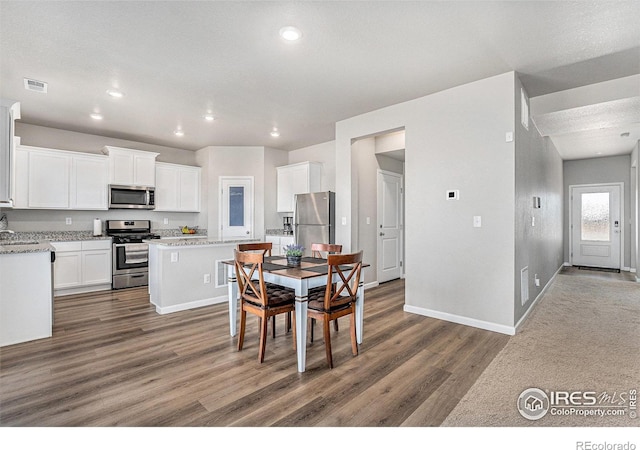 2539 Alto St, Fort Lupton, CO 80621 - dining room with recessed lighting, wood finished floors, visible vents, and baseboards