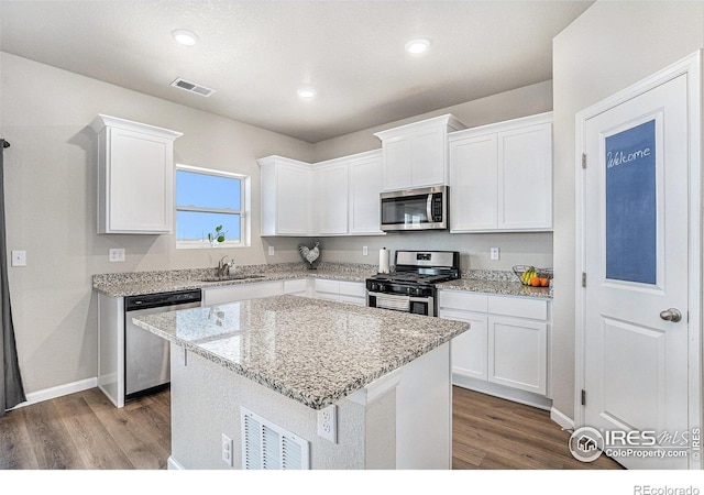 2539 Alto St, Fort Lupton, CO 80621 - kitchen featuring visible vents, wood finished floors, stainless steel appliances, white cabinetry, and a sink