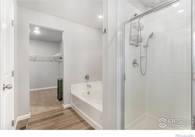 2539 Alto St, Fort Lupton, CO 80621 - full bath with a shower stall, a spacious closet, a bath, and wood finished floors