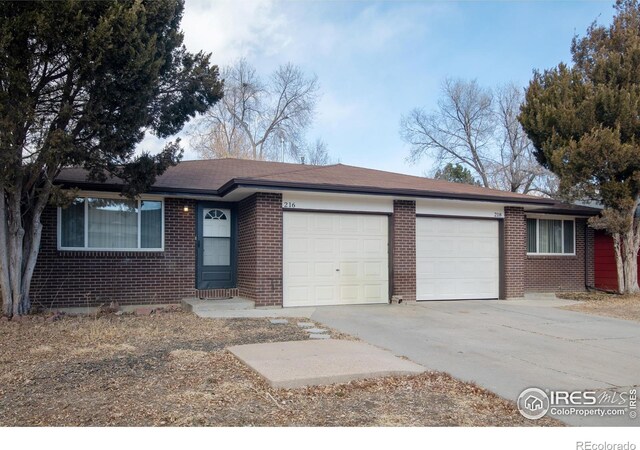 216-218 E Saint Clair Ave, Longmont, CO 80504 - single story home with a garage, driveway, and brick siding