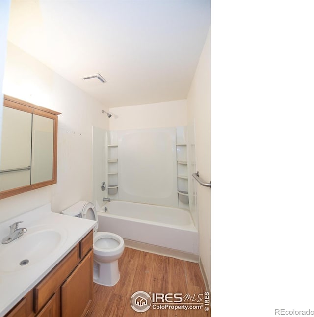 216-218 E Saint Clair Ave, Longmont, CO 80504 - full bath with visible vents, toilet, wood finished floors, vanity, and shower / bathing tub combination