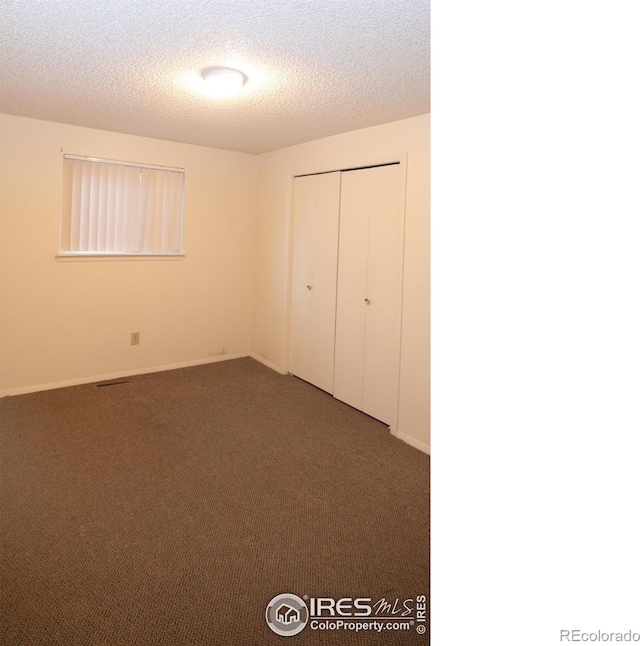 216-218 E Saint Clair Ave, Longmont, CO 80504 - unfurnished bedroom featuring a textured ceiling, carpet floors, a closet, and baseboards