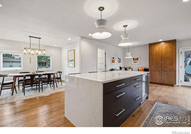 kitchen with light wood-type flooring, hanging light fixtures, and recessed lighting