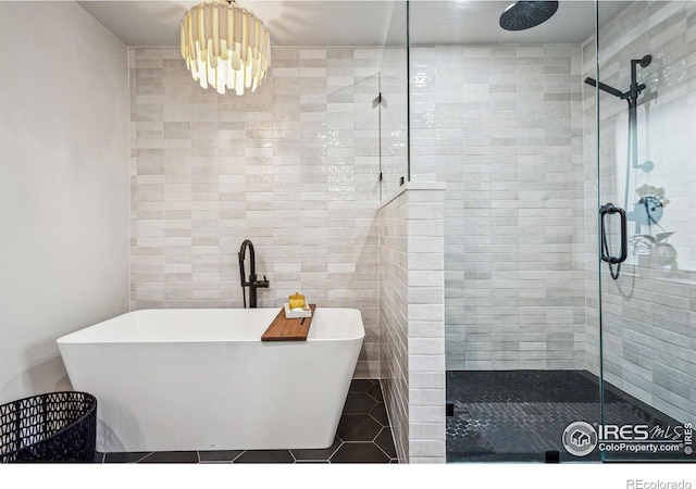 bathroom featuring a freestanding bath, a stall shower, and tile patterned flooring