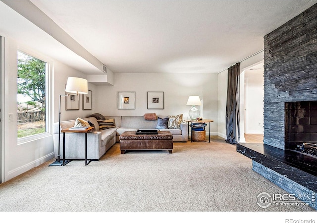 carpeted living room with baseboards, visible vents, and a high end fireplace