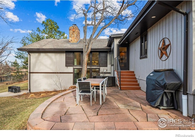 view of patio with entry steps, outdoor dining space, and grilling area