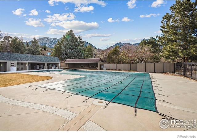 pool with fence, a mountain view, and a patio