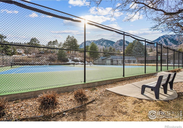 view of sport court with a mountain view and fence