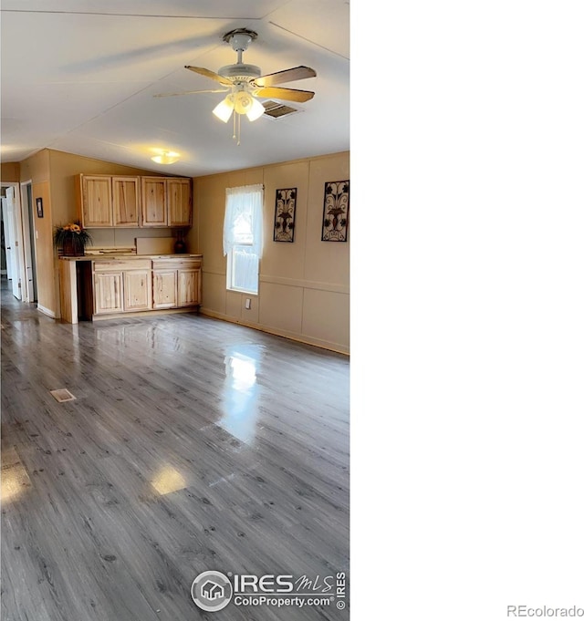 unfurnished living room with ceiling fan, wood finished floors, and visible vents