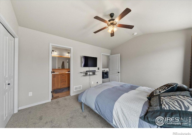 bedroom featuring carpet, lofted ceiling, a closet, visible vents, and connected bathroom