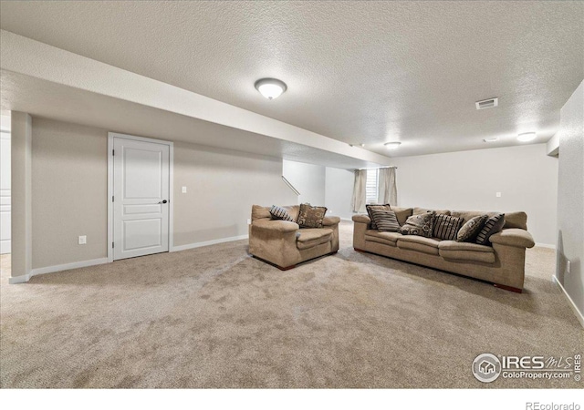 carpeted living area featuring visible vents, a textured ceiling, and baseboards