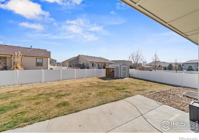 view of yard with a patio, a fenced backyard, a storage shed, an outdoor structure, and a residential view