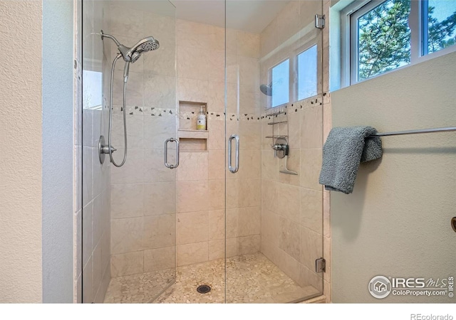 bathroom with a stall shower and a textured wall