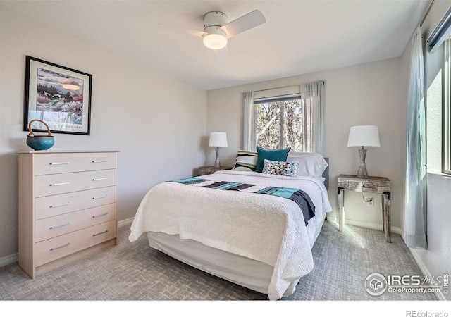 bedroom featuring ceiling fan, light carpet, and baseboards