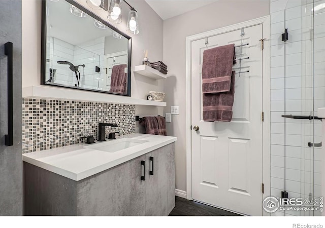 full bathroom with tasteful backsplash, a stall shower, vanity, and wood finished floors