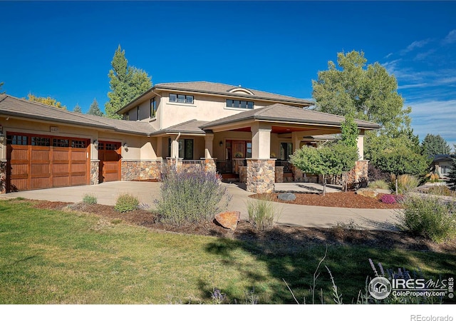 prairie-style house with a garage, stone siding, stucco siding, driveway, and covered porch