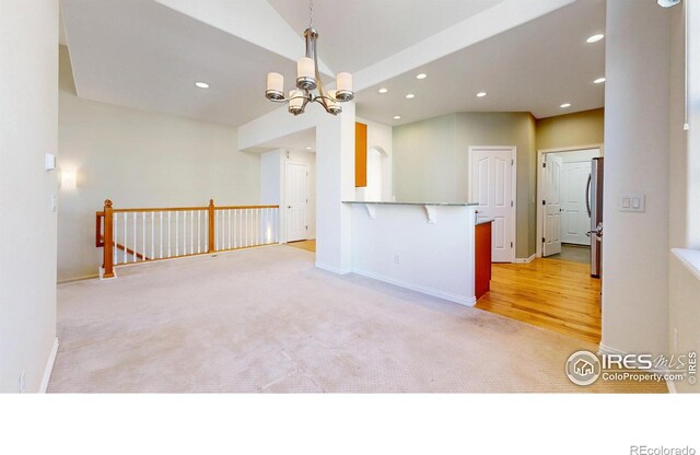 unfurnished room with recessed lighting, light colored carpet, baseboards, and an inviting chandelier