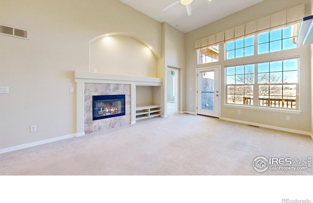 unfurnished living room featuring carpet, a fireplace, baseboards, and visible vents