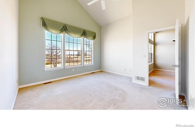 carpeted spare room featuring a ceiling fan, visible vents, high vaulted ceiling, and baseboards