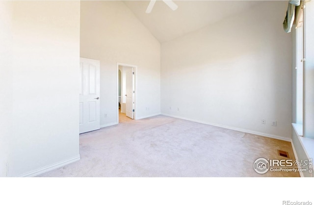 unfurnished room featuring ceiling fan, high vaulted ceiling, carpet flooring, visible vents, and baseboards