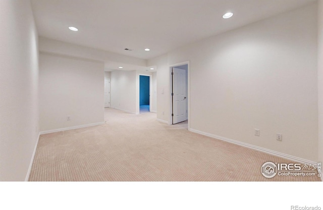 unfurnished room featuring light carpet, baseboards, and recessed lighting