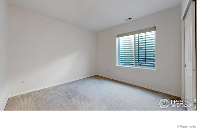 unfurnished bedroom featuring a closet, carpet flooring, visible vents, and baseboards