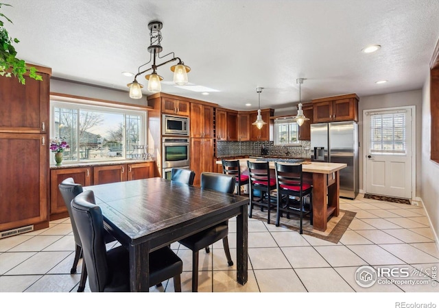 dining space with light tile patterned flooring, visible vents, recessed lighting, and a textured ceiling