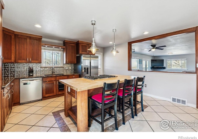 kitchen featuring a sink, stainless steel appliances, visible vents, and light tile patterned flooring