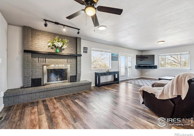 living area with a fireplace, wood finished floors, and a textured ceiling