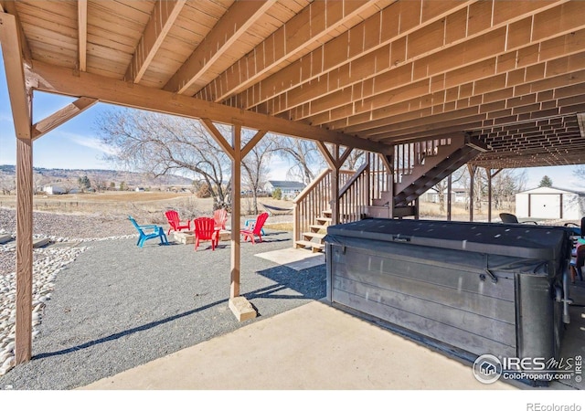 view of patio featuring stairway and a hot tub