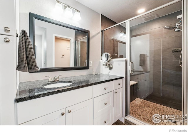 bathroom with vanity, a shower stall, and visible vents