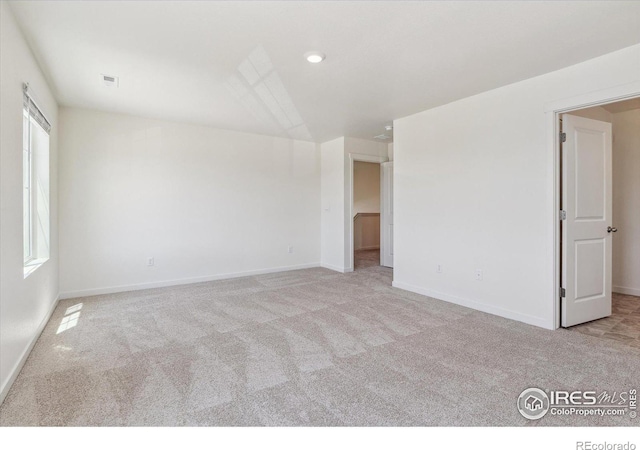 unfurnished room with carpet flooring, visible vents, and baseboards