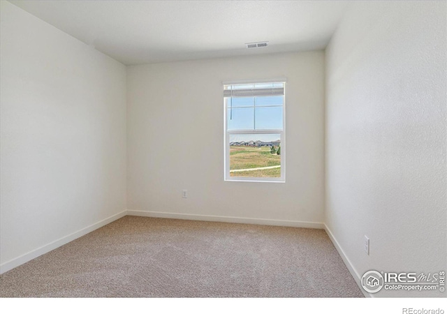 carpeted empty room featuring visible vents and baseboards