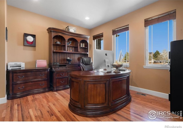 office space with light wood-style floors, recessed lighting, visible vents, and baseboards