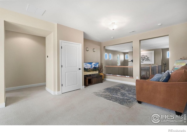 living area featuring carpet floors, visible vents, baseboards, and a tile fireplace