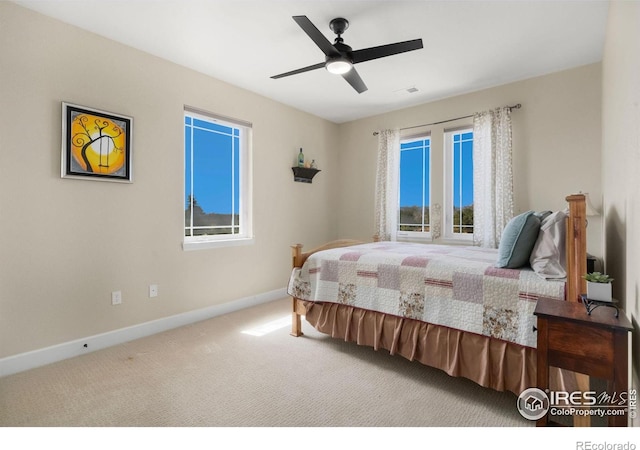 bedroom with carpet floors, visible vents, multiple windows, and baseboards