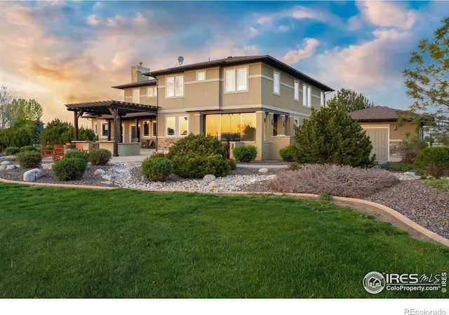 rear view of house featuring a patio, a chimney, stucco siding, a lawn, and a pergola