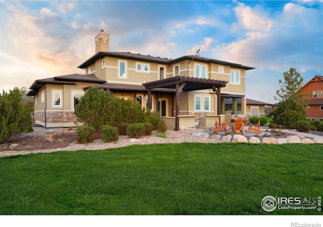 back of property featuring a chimney, a yard, a patio area, a pergola, and stucco siding