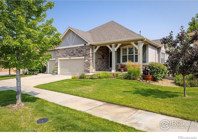 view of front of property featuring stucco siding, driveway, a front lawn, stone siding, and an attached garage