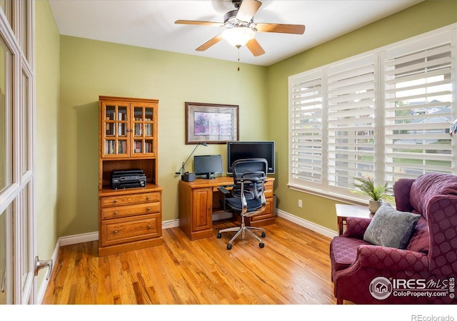 office space with light wood-type flooring, baseboards, and a ceiling fan