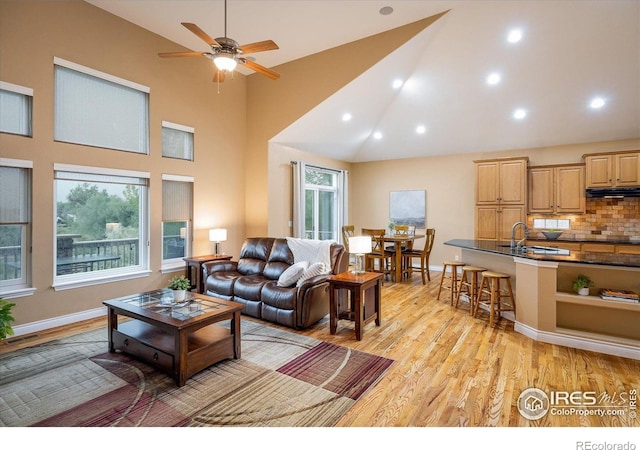 13943 W 87th Ln, Arvada, CO 80005 - living room with healthy amount of natural light, light wood-type flooring, ceiling fan, recessed lighting, and high vaulted ceiling