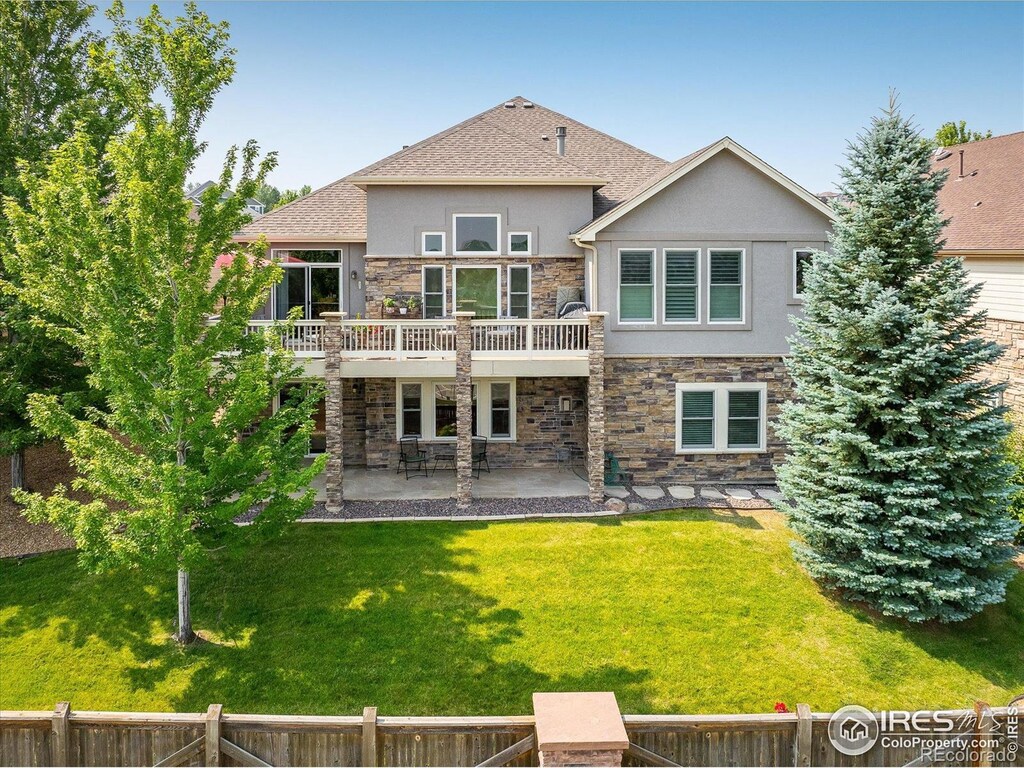 13943 W 87th Ln, Arvada, CO 80005 - rear view of property featuring stucco siding, stone siding, a patio, and a wooden deck